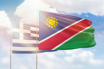 Sunny blue sky and flags of namibia and greece