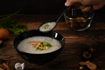 Nutritious rice porridge with shiitake mushroom, slice ginger, slice scallion and soft boiled egg for breakfast or light meal