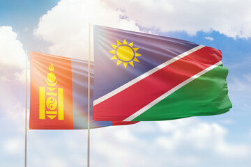 Sunny blue sky and flags of namibia and mongolia