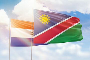 Sunny blue sky and flags of namibia and paraguay