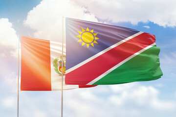 Sunny blue sky and flags of namibia and peru