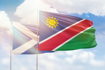 Sunny blue sky and flags of namibia and scotland