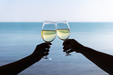 Drink two glasses white wine in hands outdoor seascape, romantic couple toast with alcohol, happy people cheering fun vacation enjoying travel time together friendship love concept congratulations.