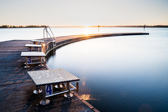 Pier at lake with natural swimming pool al sunrise