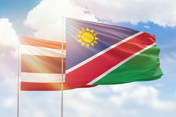 Sunny blue sky and flags of namibia and thailand