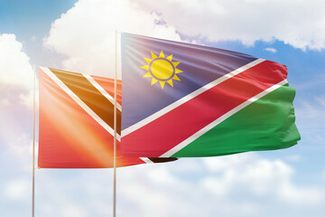 Sunny blue sky and flags of namibia and trinidad and tobago
