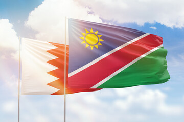 Sunny blue sky and flags of namibia and bahrain