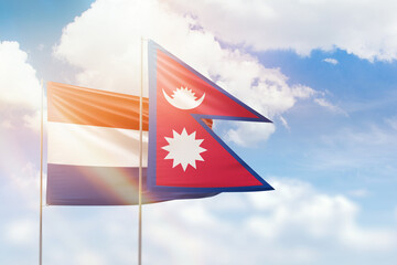 Sunny blue sky and flags of nepal and netherlands