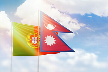 Sunny blue sky and flags of nepal and portugal