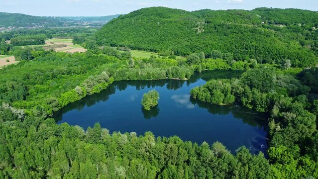 Lac bleu en France entour&eacute; de for&ecirc;ts. Etang isol&eacute; depuis une vue a&eacute;rienne.