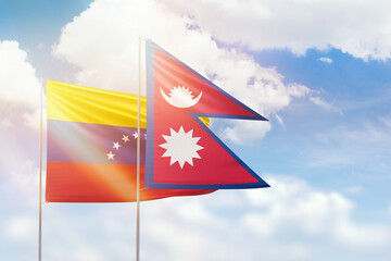 Sunny blue sky and flags of nepal and venezuela