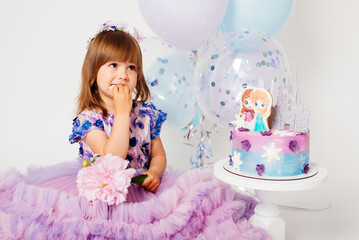 Obraz na płótnie Canvas Three years old girl in a pink dress and a birthday cake