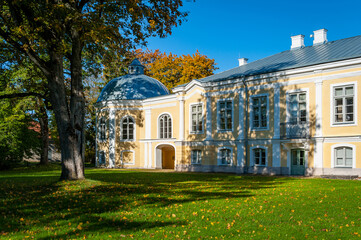 Fototapeta na wymiar Sunny autumn weather drew tourists and visitors to enjoy the beautiful Vääna Manor, Estonia. Built in the 18th centur. Main building now houses a school.