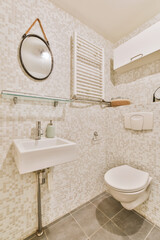 Modern toilet installed on beige wall under button and sink under mirror in light bathroom at home