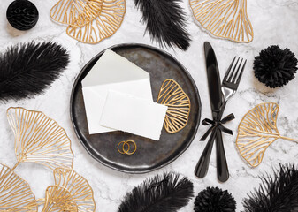 Black and golden wedding table setting with a place card and rings top view, mockup