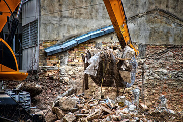 Excavator breaks old house. Freeing up space for the construction of a new building