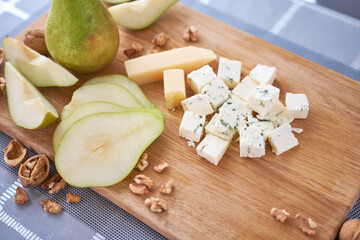 Sliced Blue cheese, pears and walnuts on wooden board