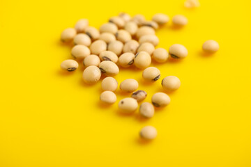 Fototapeta na wymiar Dry soybean seed on yellow background.