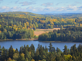 Top of Aulanko lookout tower near Hamenlinna town in Finland: colorfuls forests, lake, clouds.