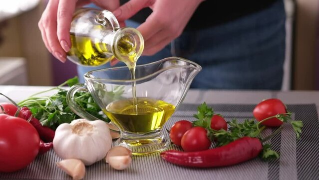 making garlic sauce - pouring olive oil into glass gravy boat