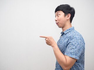 Asian man blue shirt side view excited point finger at copy space