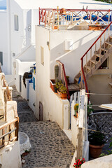 Narrow lane with colorful railings on patios and stairwells in iconic Oia on Santorini island