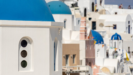 Zooming in on blue church domes in iconic Oia on Santorini island with a shallow focus