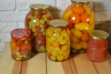Fototapeta na wymiar Pickled tomatoes. Stelanny jars with cherry tomatoes. Tomato juice. Cherry red, yellow, white.