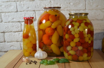 Pickled tomatoes. Stelanny jars with cherry tomatoes. Tomato juice. Cherry red, yellow, white.