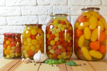 Pickled tomatoes. Stelanny jars with cherry tomatoes. Tomato juice. Cherry red, yellow, white.
