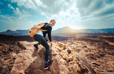 Portrait of a happy woman hiker standing on the top of mountain ridge against mountains - Sport and...