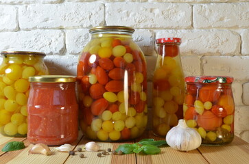 Pickled tomatoes. Stelanny jars with cherry tomatoes. Tomato juice. Cherry red, yellow, white.