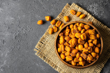 Roasted salted Corn Nuts with Spice and Sauce in bowl on dark rustic table, Nut concept