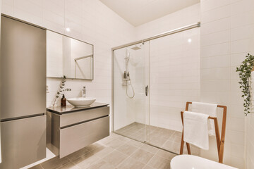 Bathroom with grey silver cabinets,towel dryer,sink,shower cabinet