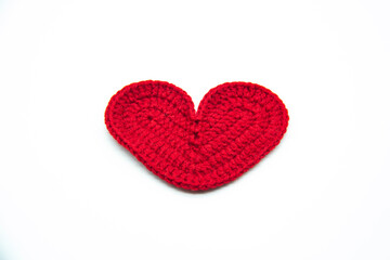 A red heart woven from red threads isolated on the white background