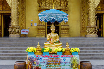 Golden buddha statue under the umbrella in songrand festival at Sri Pan Ton temple Nan district,...