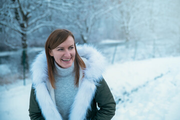 beautiful girl in warm clothes, laughing cheerfully contagiously, against the backdrop of...