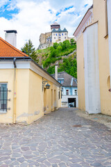 Ancient street at Trencin city, Slovakia. View of old street with ancient castle above. Summer day.