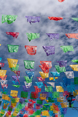 colorful mexican flags with a blue sky with clouds
