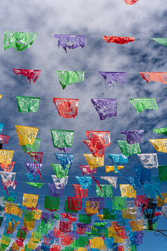 Colorful Mexican Flags With A Blue Sky With Clouds