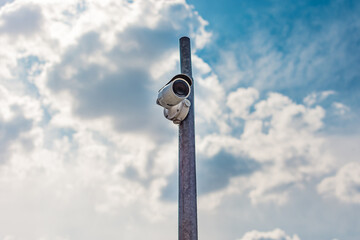 Wireless camera surveilling traffic while mounted on a pillar on a cloudy day