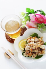 Chinese food, deep fried chicken soft bon on white dish served and glass of beef