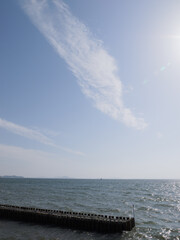 Clear blue sky over the lake and pure white bands of clouds