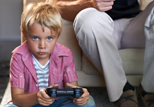 Focused on the game. A young boy playing video games at home.