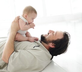 Fototapeta premium Young father lying on floor at home and