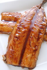 Japanese food, sweet soy sauce and grilled pacific saury Santa fish on white plate