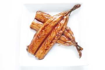 Japanese food, sweet soy sauce and grilled pacific saury Santa fish on white plate