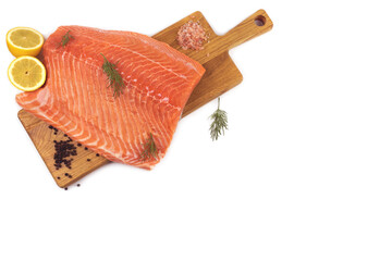 Red fish in lemon juice. The fish lies on a wooden board, around dill and black pepper.