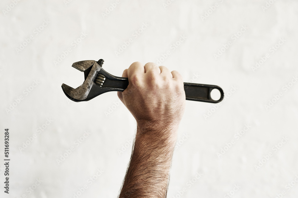 Poster The all powerful monkey wrench. Shot of an unrecognizable handyman holding up a monkey wrench.