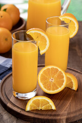 Two glasses of orange juice with sliced oranges